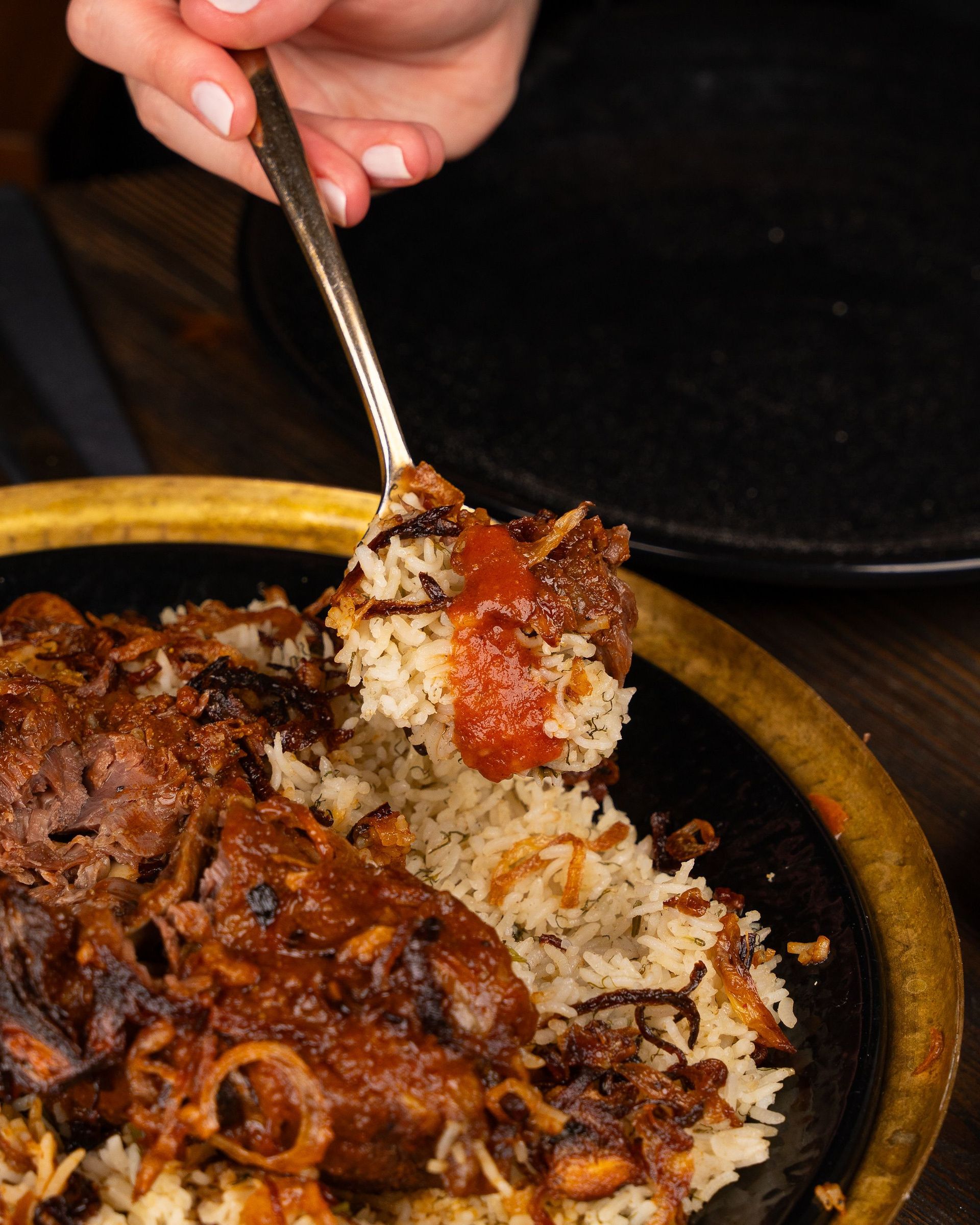 A savory spiced lamb dish paired with rice and tomatoes. Perfect for gourmet dinners.