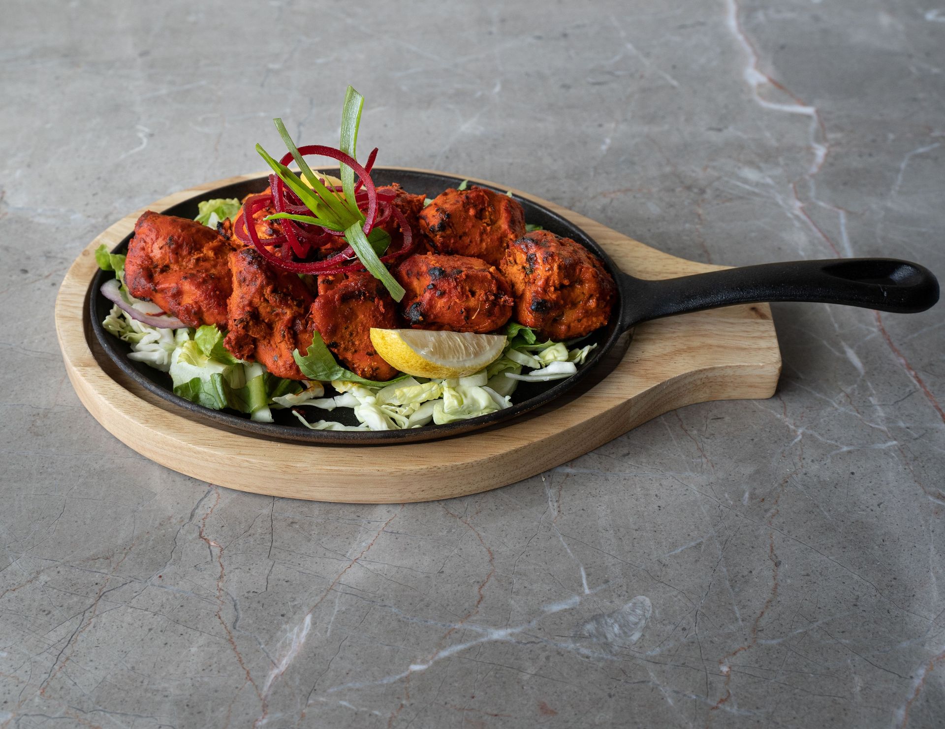 Mouthwatering tandoori chicken arranged on a sizzling platter, perfect for authentic Asian cuisine lovers.